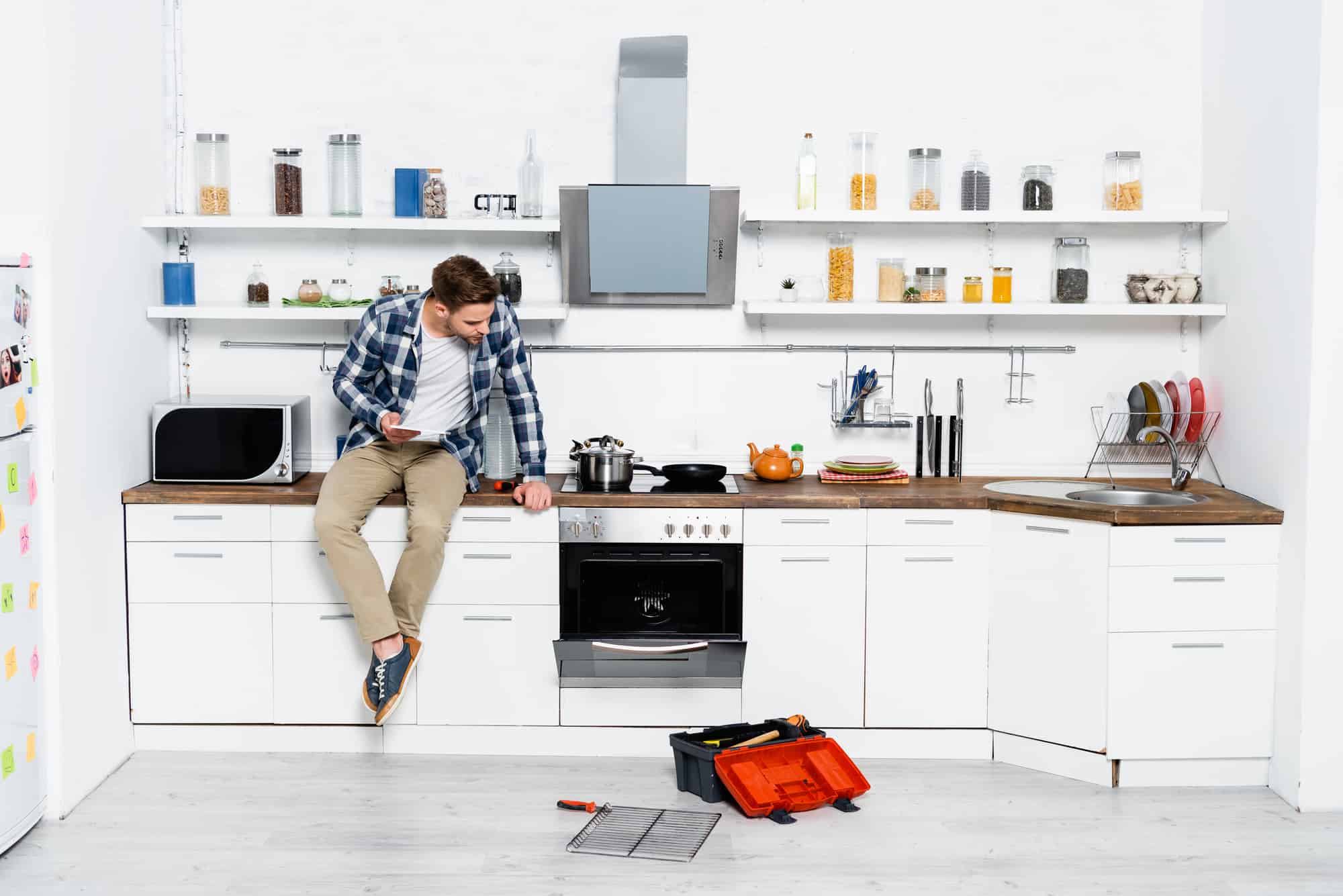 hombre joven sentado sobre mesón de la cocina